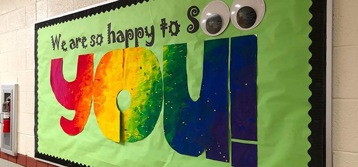 bulletin board reading We are so happy to see you