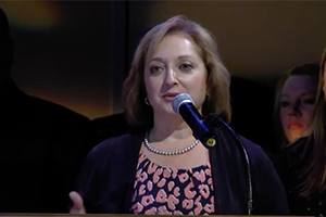Rae Connelley speaks at podium after winning award