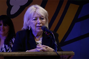 Linda Palles speaks at podium after winning award