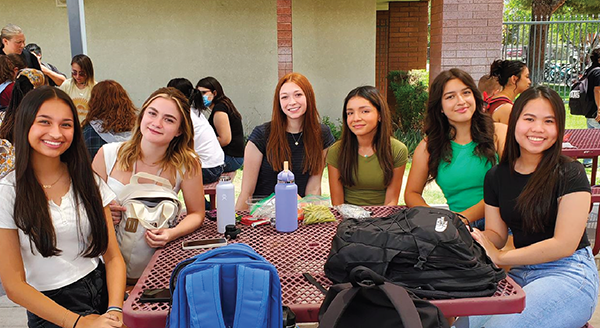 high school students sit around an outdoor lunch table